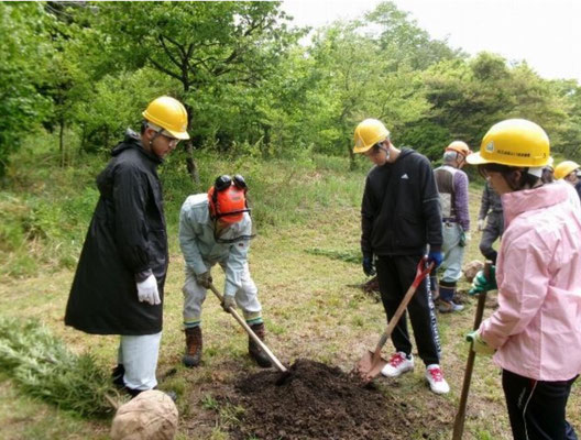 土と腐葉土を混ぜる鍬の使い方の指導