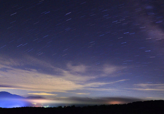 写真３．「幽玄」 　遠くのシャトレーゼスキー場の灯りと、星の軌跡を組合わせてみました。