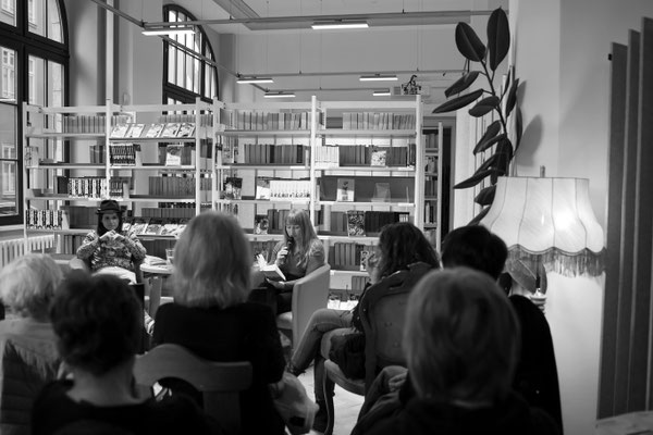 Malina Bura sitzt vor Publikum in der Stadtbibliothek Erfurt und spricht in ein Mikrofon. Sie liest aus ihrem Buch "Der Geschmack meiner Jugend".