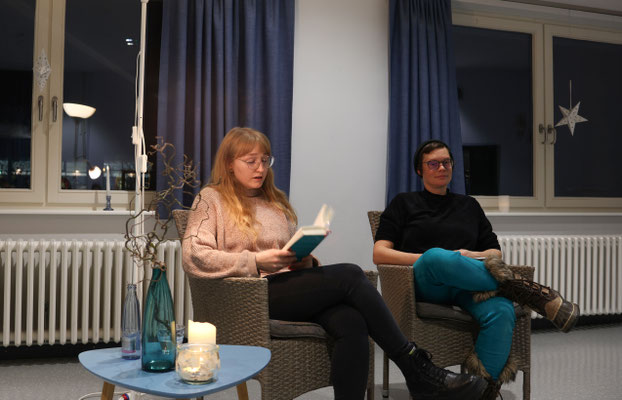Neben einer Moderatiorin sitztend, liest Malina Bura bei einer Lesung in Lüchow Wendland aus ihrem Buch und spricht über Gewalt an Frauen.