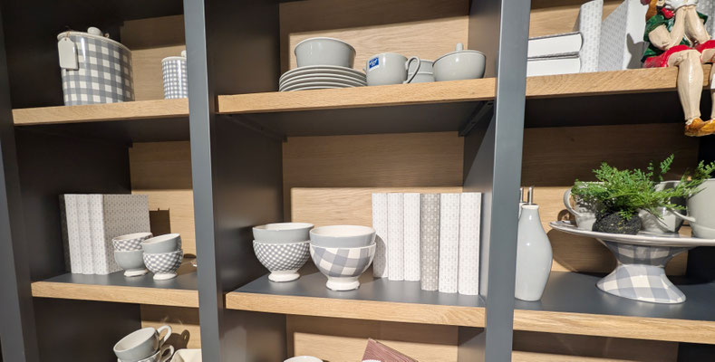Weißer Schrank mit Glastüren, Holzfächern und beleuchteten Dekorationen.