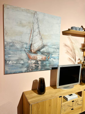 Ein Ölgemälde eines Segelboots auf dem Meer hängt über einem TV auf einem Holzschrank.