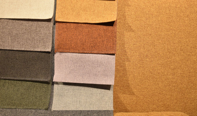 Stoffmuster in Naturtönen, einschließlich Beige, Grau, Braun und Olivgrün, sowie Senfgelb.