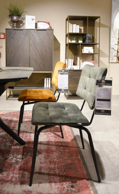 Möbel-Set aus Naturholz, dunkelgrauen Akzenten und Stoffstühlen in Olivgrün, Braun und Grau.