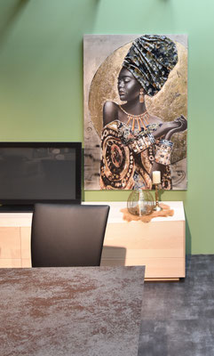 Holz-TV-Schrank mit Fernseher hinter einem Tisch mit Stuhl. Darüber ein Gemälde einer Frau.