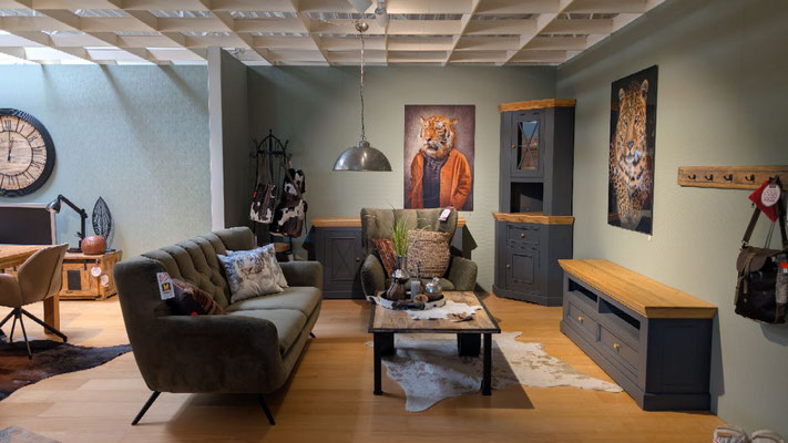 Ein Wohnzimmer mit dunkelgrauen Möbeln mit Holzoberflächen, ein Sofa, Sessel und Couchtisch.
