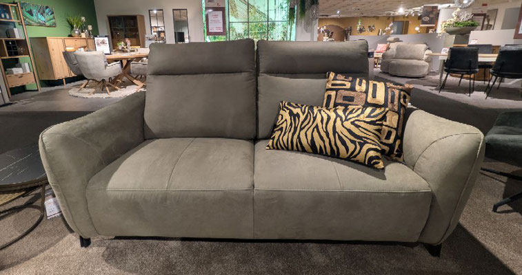 Modernes, graubraunes Zweisitzer-Sofa mit zwei gemusterten Zierkissen in einem Möbelgeschäft.