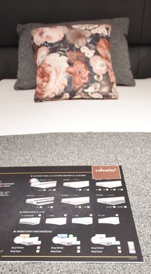 Detaillierte Ansicht einer Matratzenübersicht (Wohnnatur) auf einem Bett. Kissen mit Blumenmuster.