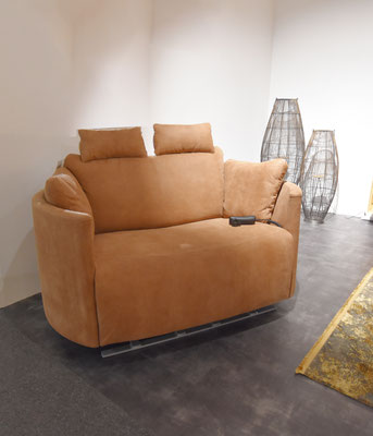 Hellbraunes Sofa mit Entspannungsfunktion und einem Kabelfernbedienungspad auf der Sitzfläche.