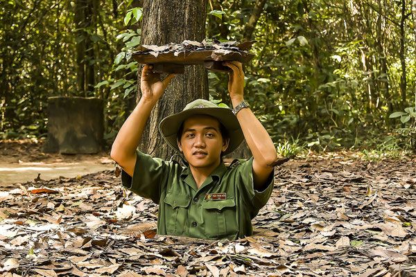 Vietnamesischer Soldat zeigt den Eingang zum Tunnelsystem des Vietcong in Chu Chi, Vietnam, Asie