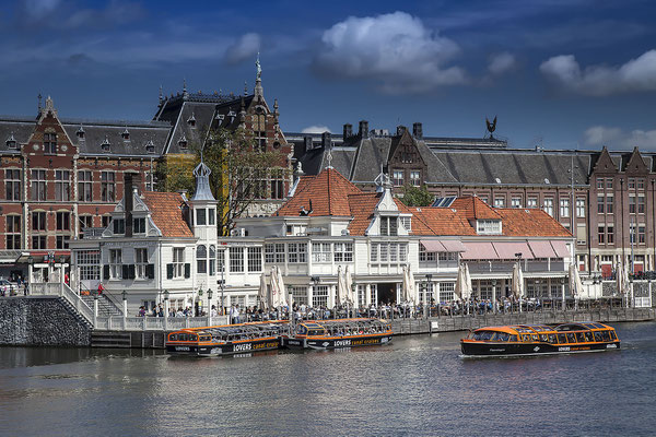 Der Hauptbahnhof von Amsterdam, im Vordergrund ein Bootsanleger für Grachtenrundfahrten, Amsterdam, Holland, Niederlande,Europa