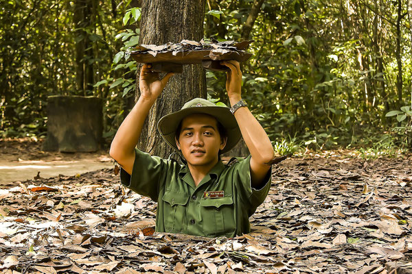 Vietnam soldier showing the entrance to the tunnel system of the Viet Cong in Chu Chi, Vietnam, Asia