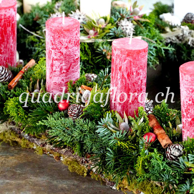 Adventsgesteck lang in Grün und Rot Farben.