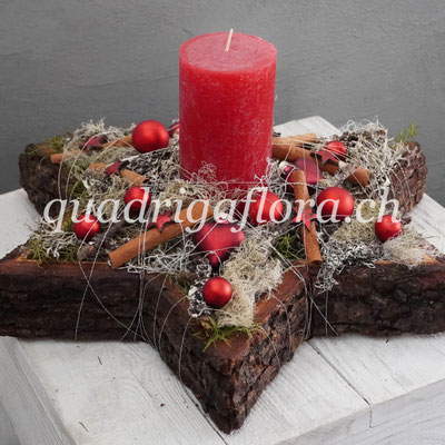 Gesteckter Advents Stern aus Holz mit roter Kerze und Weihnachtsdekoration.