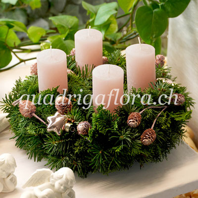 Grosser Adventskranz mit frischem Grün und vier helle Kerzen.