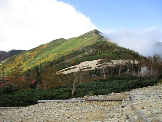 到着後、暫くすると乗越の右・左の山もガスが晴れてきた　こちらが横通山の方