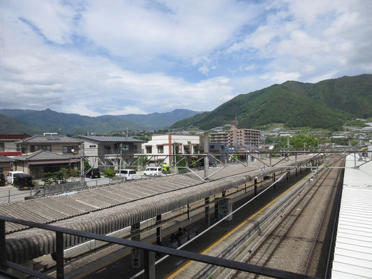 塩山駅に到着　ちょうど遠景の中央に大菩薩嶺が見える