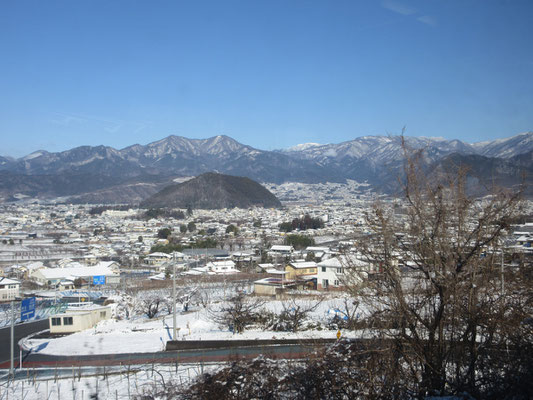 目を転じると、塩山市街と向こうの山並み　まさに山村正光著『車窓の山旅 中央線から見える山』の世界　遠くの白い山は金峰山だ