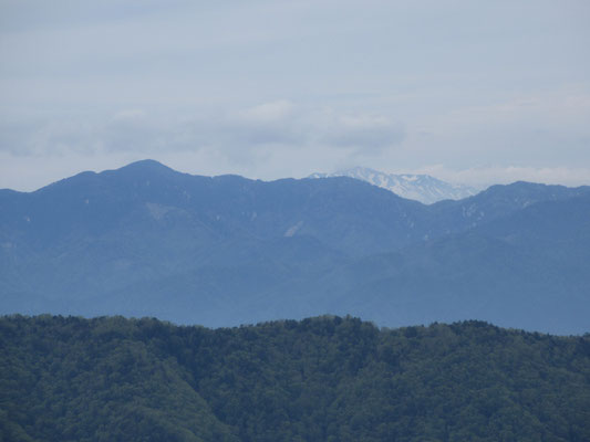 そして遠くに小さく白い斑模様の山が見えた　御嶽山