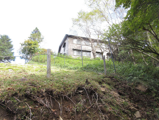 その内、介山荘が見えて来た　山小屋の周囲はシカ柵で囲っている為、左部分の囲われていない所と右の内側とでの植生のあまりの違いに驚く