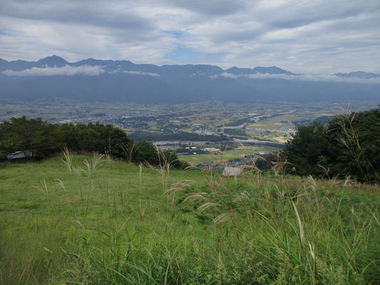 長峰山山頂の広い草原越しに正面に北アルプスが連なる