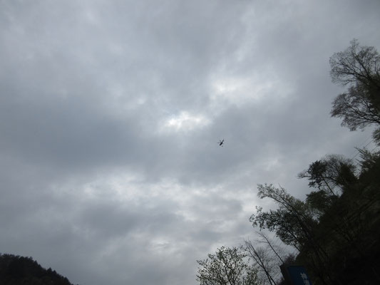 到着した上野村の上空　ヘリが消火剤をぶら下げて山に向かっている