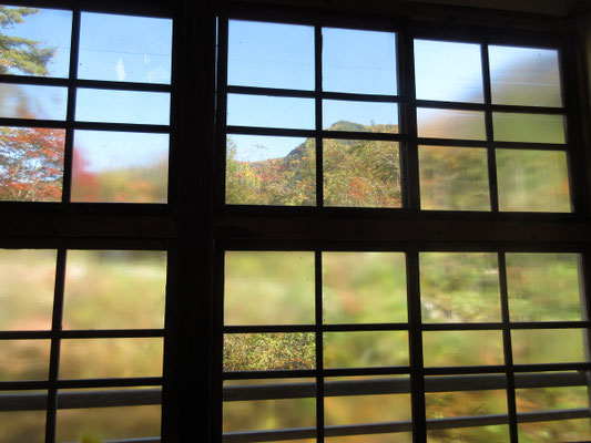 二階の窓から透けて見える紅葉の山 古いガラスなので曇っているのが味わい深い