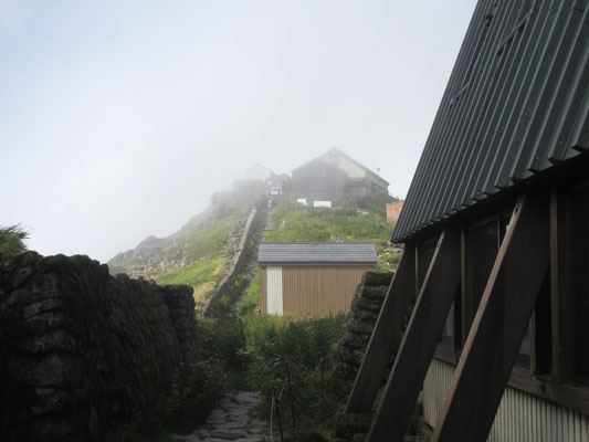 小屋のすぐ上に神社がある　小屋の隣に立派なバイオトイレがある