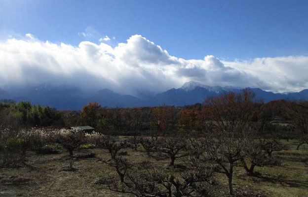 上空は青空だが、風に押された雲が高い山々を覆うようにかかる