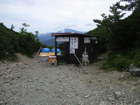 外に設置されたトイレ小屋  奥に用済みの携帯トイレの回収箱があります　集めたものはヘリで下ろします