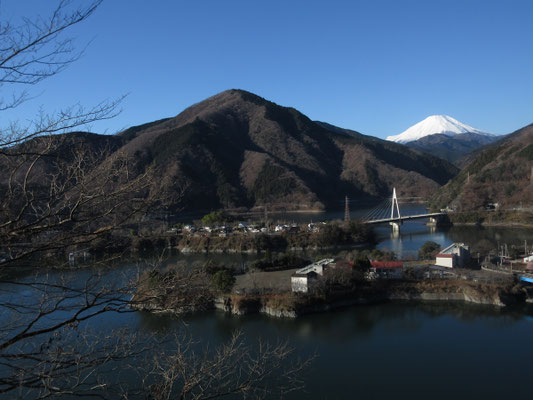 丹沢湖は周りを山に囲まれているので前山に隠れて富士山の裾野は見えないが、すでに真っ白な姿は圧巻　左手前の三角錐の山は太郎小屋山