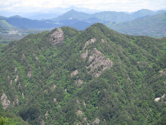 反対の東側を見れば、この京ヶ倉山と同じような岩峰の山々が林立する　これは大昔、海底に堆積した水平な地層が地下で折れ曲がり（褶曲構造）更に地表に現れ、最終的に侵食に強い地層が残ったとのこと