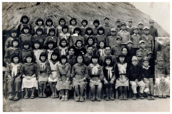 1945年終戦直後の中学茅葺校舎前の中学生と当時の教員と共に。