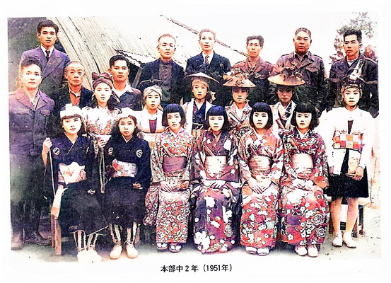 1951年昭和26本部中学学芸会で2年生の女子学生に松竹梅鶴亀を教えた渡久地の豊年祭の指導者の皆さんと。