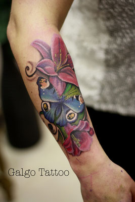 Tatuaje realista de una maripos azul con un fondo de flores rosas. Blue butterfly realistic tattoo