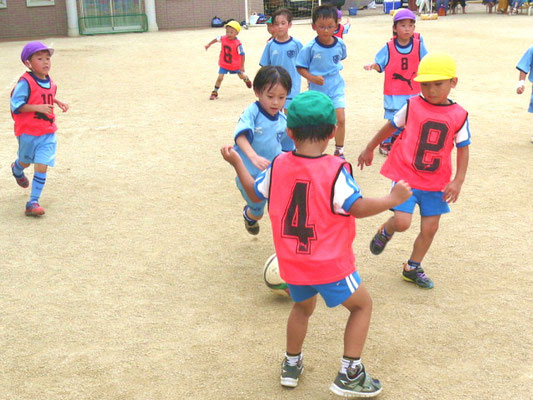 園庭でサッカーをしている子どもたち３