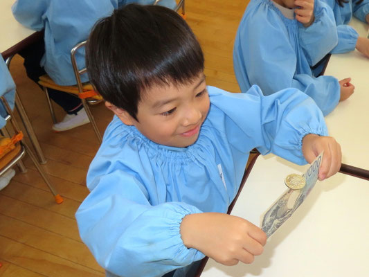 子供がお札を使って科学マジック体験をしている様子