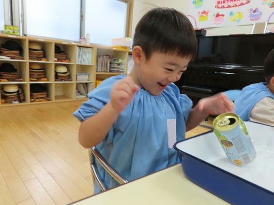 子供が空き缶を使用して科学マジック体験をしている様子