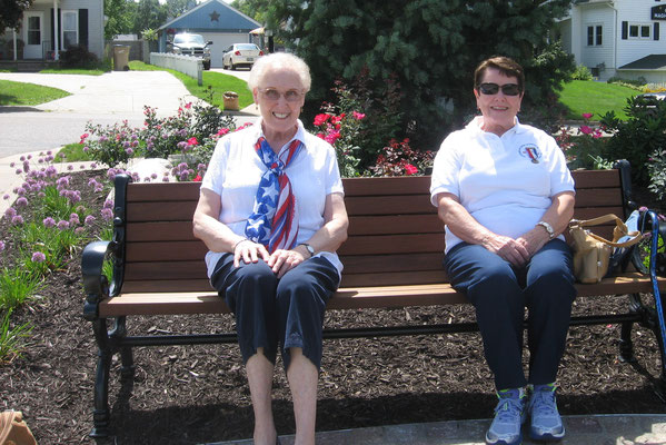 Wenda and Dian sit on a nearby bench by the flagstone path in front of the museum