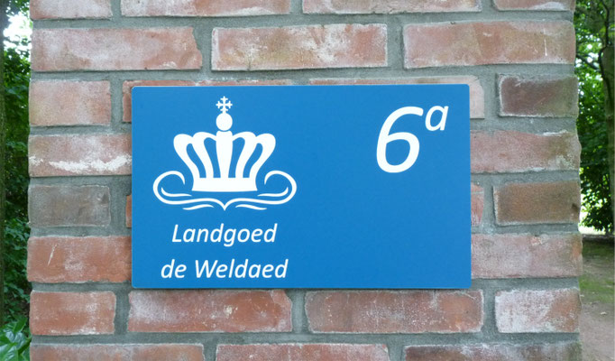 Muurplaat met logo en huisnummer uitgesneden en gegraveerd.