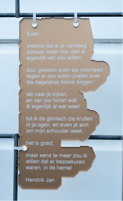 Gedicht in transparant goudkleurig plexiglas gegraveerd.