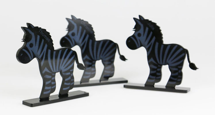 Zebra's uitgesneden en gegraveerd in zwart plexiglas, daarna verlijmt op de plexiglas standaard.