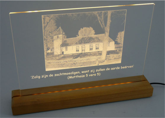 Plexiglas met led-verlichting, houten standaard en adapter met een gravering van een foto.