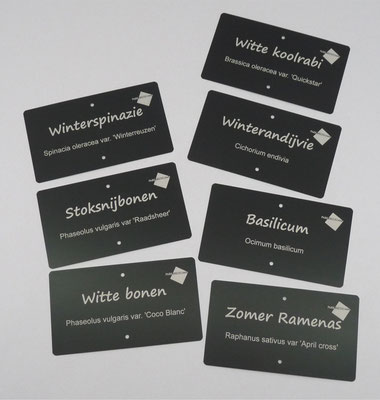 Zwarte aluminium plaatjes met witte tekst en logo.