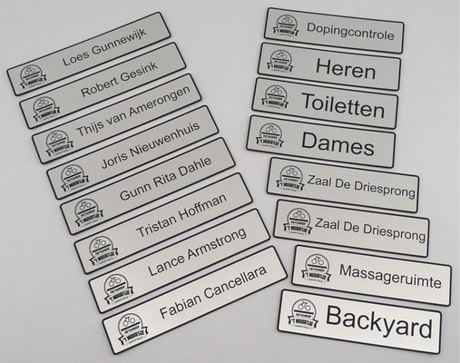 Kunststof plaatjes uitgesneden en gegraveerd met logo en tekst.