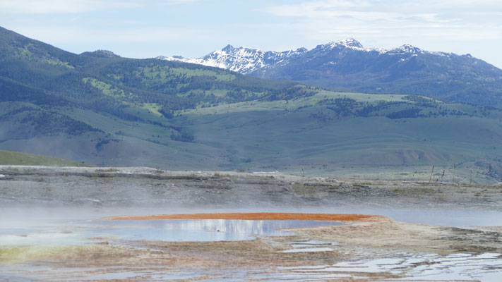 rot gefärbtes heißes Wasser vor Bergpanorama in Yellowstone