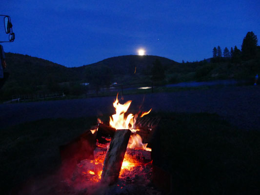 Der Mond geht hinter dem Hügel auf und wir sitzen am Lagerfeuer