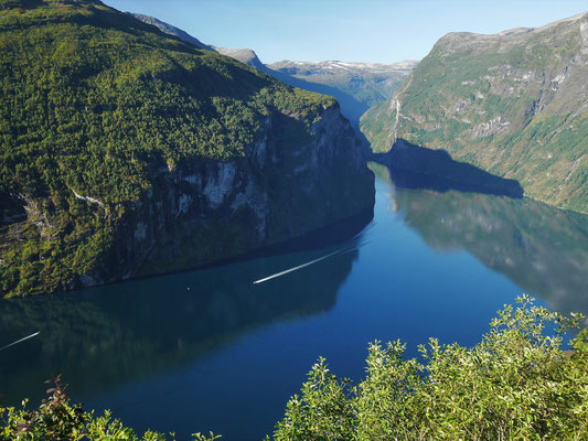 Der Blick in den Fjord, oben kurz unterhalb der Geländekante, die an der markanten Felswand endet, liegt Homlomgsetra, wo wir am Vortag vorbeigewandert waren