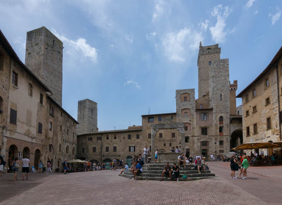 Die Piazza della Cisterna mit dem großen Brunnen. Rechts hinten der Torre Grossa, der höchste der Türme.