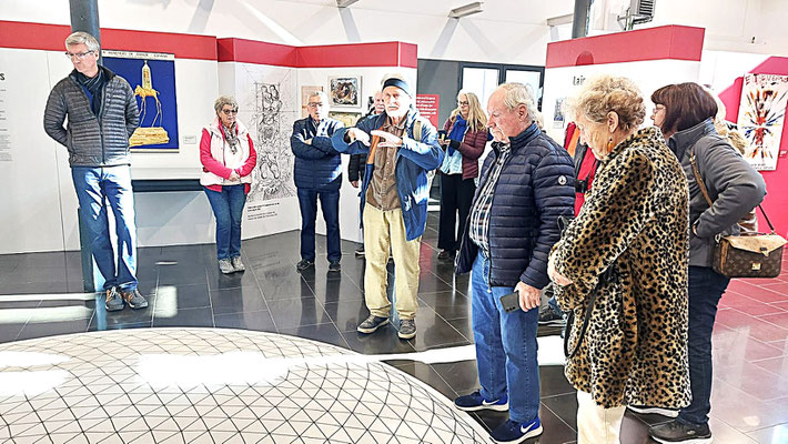 Unsere Gruppe vor einer Skizze der geodätischen Kuppel auf dem Boden in der Ausstellung